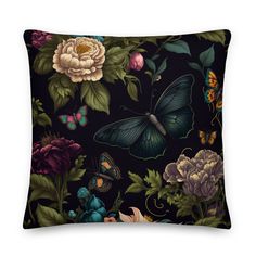 a black pillow with colorful flowers and butterflies on the front, along with a dark background