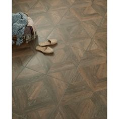 a pair of slippers sitting on top of a wooden floor next to a blanket