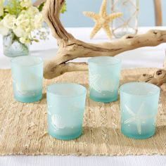 four blue glass cups sitting on top of a table