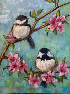 two birds sitting on a branch with pink flowers