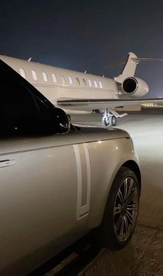 a car parked in front of an airplane at night