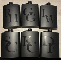 six black flasks with the letter g and w on them are stacked together