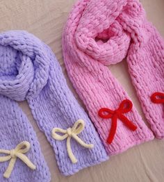 three knitted scarves with bows on them