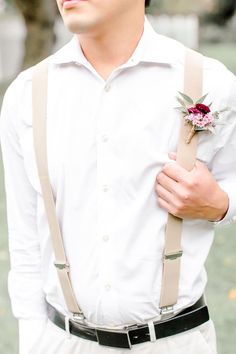 a man with suspenders and a flower in his lapel