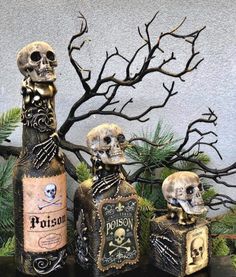 three skulls sitting next to each other in front of a tree with two bottles on it