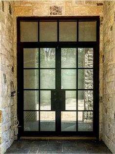 an open door with glass and stone walls