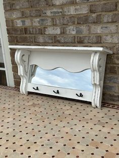 a white bench sitting next to a brick wall