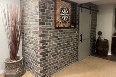 a room with a brick wall and darts on the wall