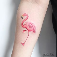 a pink flamingo tattoo on the arm