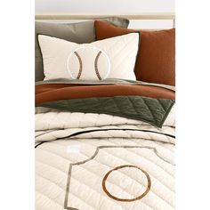 a baseball themed comforter set on a bed with brown and white pillows, along with an orange pillow case