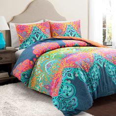 the comforter is bright and colorfully decorated with an intricate paisley pattern on it