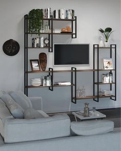 a living room filled with furniture and a flat screen tv mounted on a wall above it