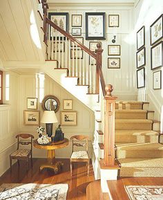 the stairs in this house are decorated with pictures and framed on the wall above them