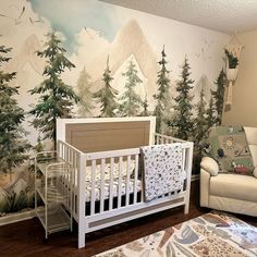 a baby's room with a mountain mural and crib in the foreground