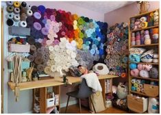 a room filled with lots of different types of yarn on the wall and shelves next to it