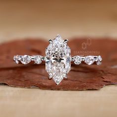 an oval cut diamond engagement ring on top of a leaf