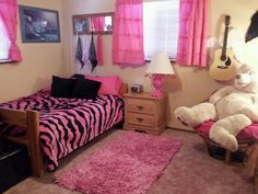 a bedroom decorated in pink and black with a zebra print bed spread on the floor