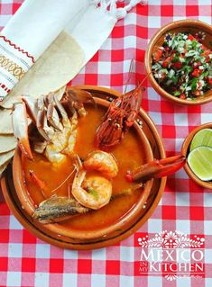 some food is on a red and white checkered table cloth next to small bowls