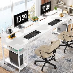 an office desk with two computer monitors on top of it and chairs in front of them