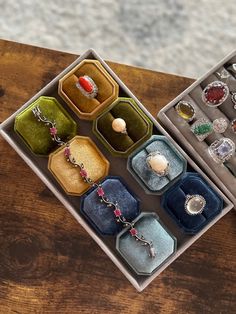 an open jewelry box on a table with several rings and bracelets in each case