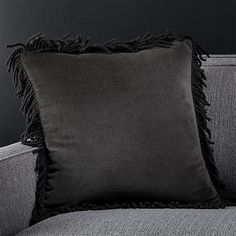 a black pillow sitting on top of a gray couch