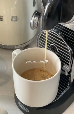 coffee being poured into a cup in front of an espresso machine with the words good morning written on it