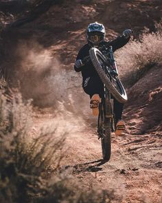 a man riding a bike down a dirt road