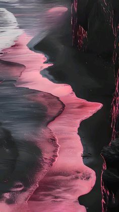 the water is pink and black with some waves coming up on it's shore