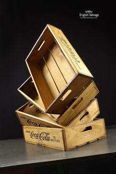 three wooden boxes stacked on top of each other with coca - cola written on them