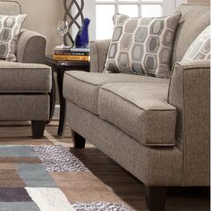 a living room scene with focus on the couch and chair, coffee table and rug