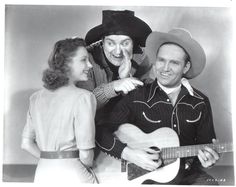 an old black and white photo of two people playing the guitar with a man wearing a cowboy hat