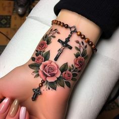 a woman's foot with a cross and roses tattoo on it