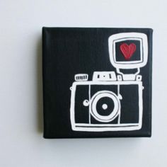 a black and white square with a red heart on it