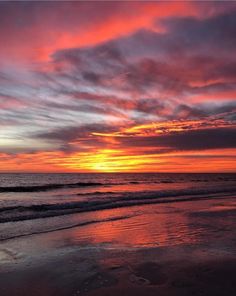 a person walking on the beach at sunset