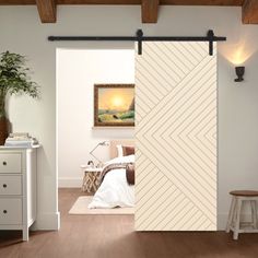 an open door leading to a bedroom with white walls and wood floors, along with a painting on the wall