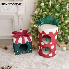 two cardboard christmas gifts sitting next to a tree in front of a decorated christmas tree