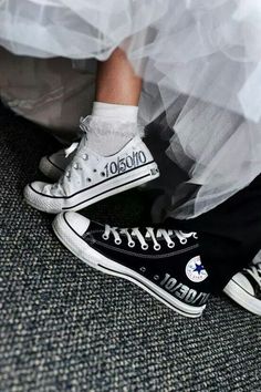 a bride and groom's feet in black converse shoes with white socks on their wedding day