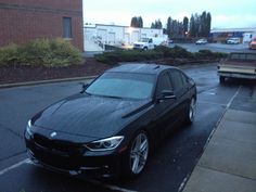 a black bmw parked in a parking lot