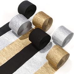 several rolls of black, gold and silver tape