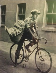 a man riding on the back of a bike down a street next to a building