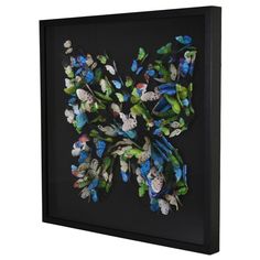 a butterfly made out of flowers in a black frame