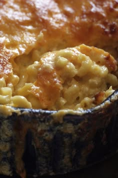 a casserole dish is shown with a fork in it and has cheese on top