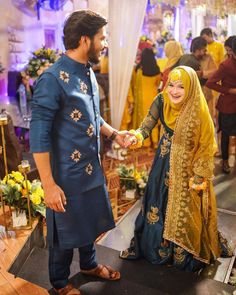 a man and woman standing next to each other in front of a group of people