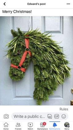 a horse head made out of evergreen leaves and red ribbon hanging on the front door