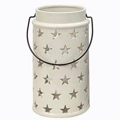 a white bucket with silver stars on the outside and black handles, hanging from a string