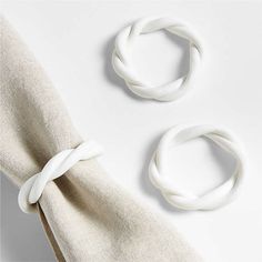 two pieces of white fabric tied together on top of each other with knoted ends