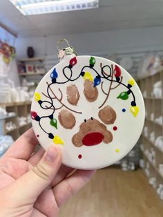 a hand holding a christmas ornament in a store