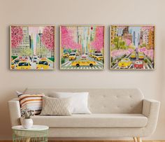 three paintings hang on the wall above a couch