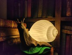 a snail lamp sitting on top of a pile of books