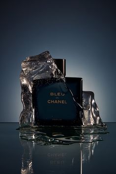 a bottle of chanel perfume sitting on top of water